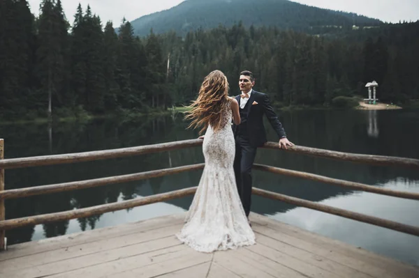 Schöne wunderschöne Braut posiert für Bräutigam und Spaß haben, luxuriöse Zeremonie in den Bergen mit herrlicher Aussicht, Platz für Text, Hochzeitspaar — Stockfoto