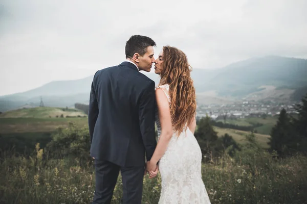 Prachtige prachtige bruid poseren om bruidegom en het hebben van plezier, luxe ceremonie in de bergen met een prachtig uitzicht, ruimte voor tekst, bruiloft paar — Stockfoto