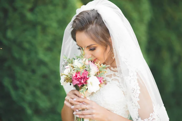 Hermosa novia joven de lujo en vestido de novia posando en el parque — Foto de Stock