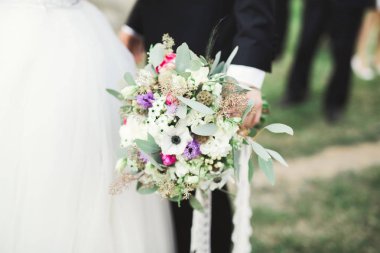 Çiçek buketi taşıyan mükemmel bir düğün çifti.