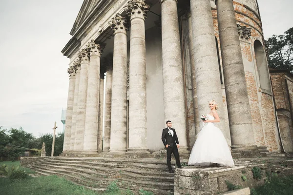 Güzel, romantik bir düğün. Yeni evliler. Eski kalenin yakınlarında sarılıyorlar. — Stok fotoğraf