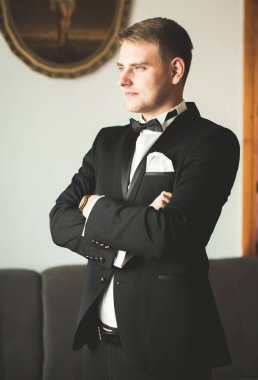 Güzel adam, damat poz veriyor ve düğüne hazırlanıyor.