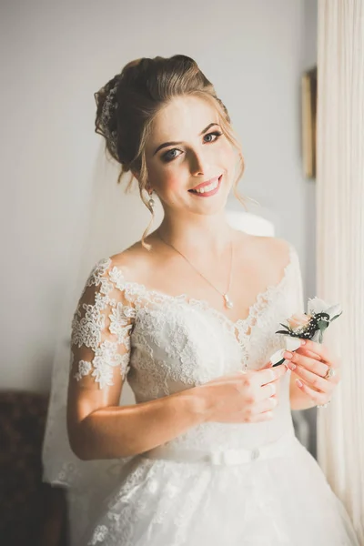 Linda noiva em roupão posando e se preparando para o rosto cerimônia de casamento em uma sala — Fotografia de Stock