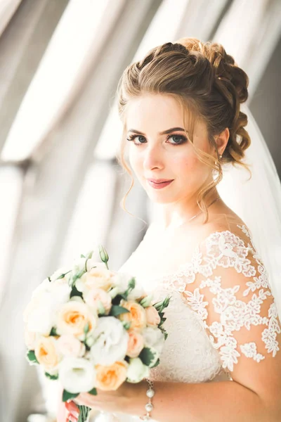 Retrato de novia impresionante con el pelo largo posando con gran ramo — Foto de Stock