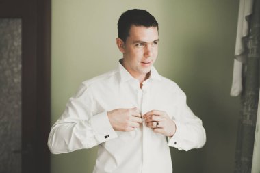 Güzel adam, damat poz veriyor ve düğüne hazırlanıyor.