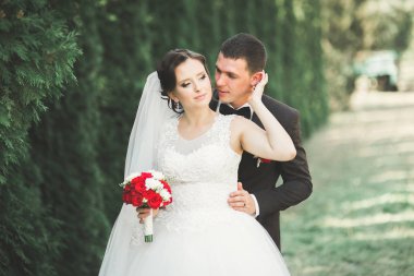 Yeni evli çift el ele tutuşurken parkta koşup zıplıyorlar.