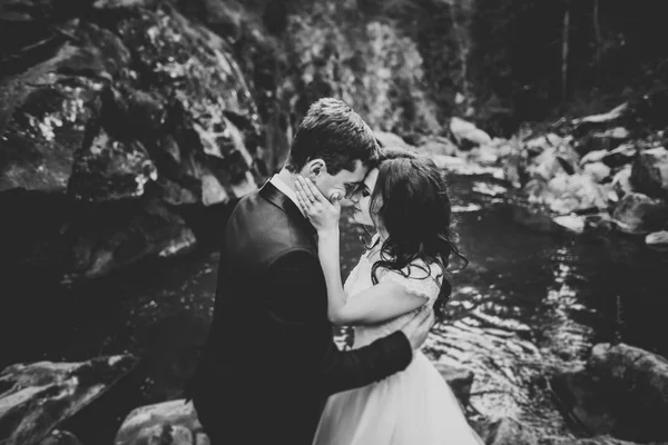 Couple de mariage, marié et mariée câlin, en plein air près de la rivière — Photo