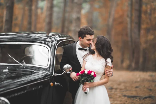 Apenas casal no carro retro de luxo em seu dia do casamento — Fotografia de Stock