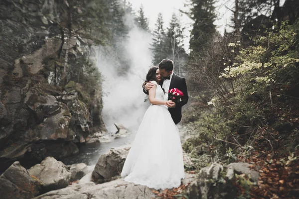 Великолепная невеста, позирующая жениху и веселящаяся, роскошная церемония в горах с изумительным видом, пространство для текста, свадебная пара — стоковое фото