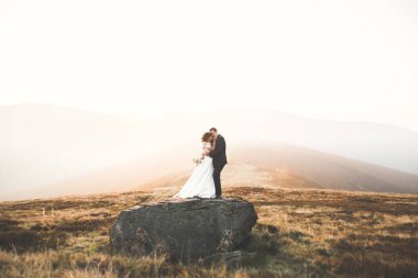 Harika bir gelin damada poz veriyor ve harika manzaralı dağlarda lüks bir tören yapıyor.