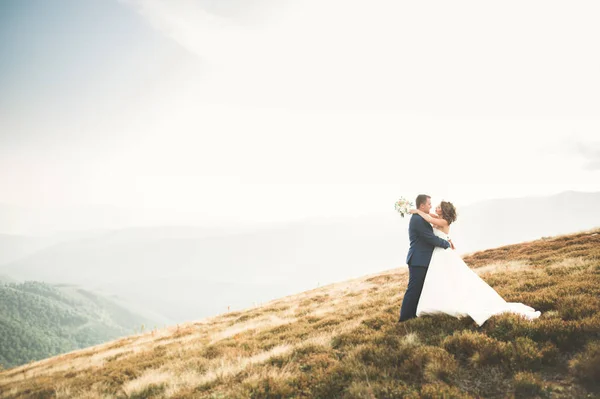 Hermosa novia hermosa posando para el novio y divertirse, ceremonia de lujo en las montañas con una vista increíble, espacio para el texto, pareja de boda —  Fotos de Stock