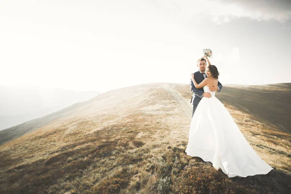 Casal de casamento posando no pôr do sol no dia do casamento. Noiva e noivo apaixonados — Fotografia de Stock