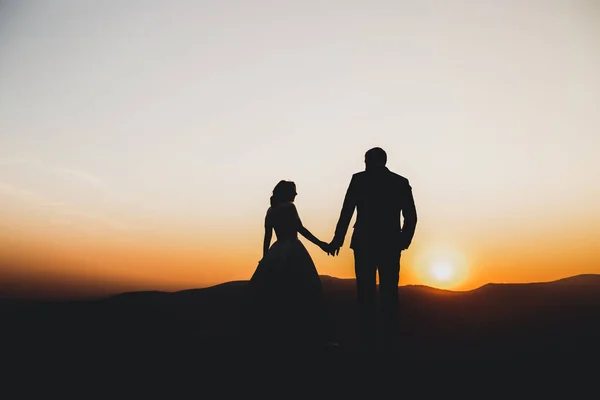 Felice bella coppia di sposi sposa e lo sposo il giorno del matrimonio all'aperto sulla roccia montagne. Felice matrimonio coppia all'aperto sulla natura, luci soffuse e soleggiate — Foto Stock