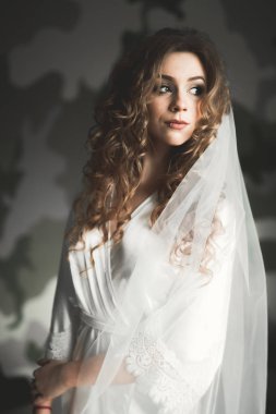 Beyaz elbiseli lüks gelin düğün törenine hazırlanırken poz veriyor.