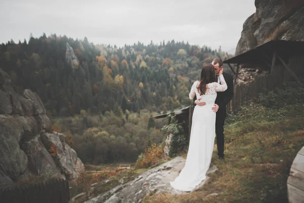 Casamento casal no amor beijando e abraçando perto de pedras na bela paisagem — Fotografia de Stock