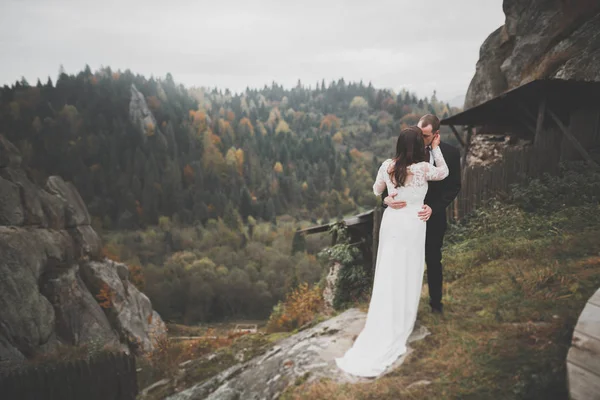 Wedding couple in love kissing and hugging near rocks on beautiful landscape — Stock Photo, Image