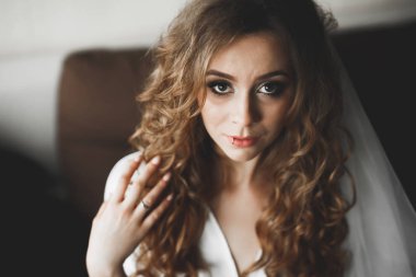 Beyaz elbiseli lüks gelin düğün törenine hazırlanırken poz veriyor.