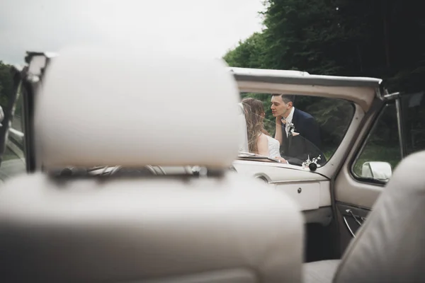 Elegante coppia di nozze, sposa, sposo baci e abbracci su auto retrò — Foto Stock