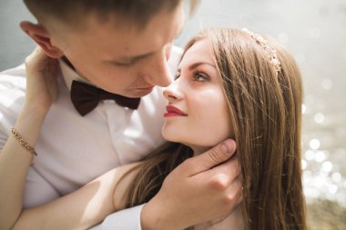 Bahar mevsiminde öpüşen düğün çifti. Yakın plan portre.