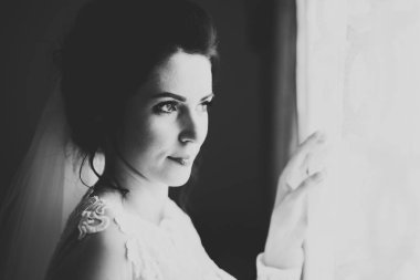 Cüppeli muhteşem gelin bir odada düğün töreni için poz veriyor ve hazırlanıyor.