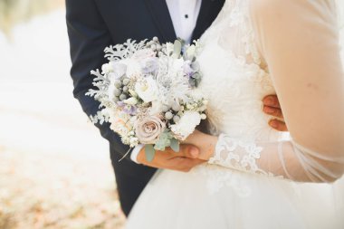 Yeni evli çift el ele tutuşurken parkta koşup zıplıyorlar.