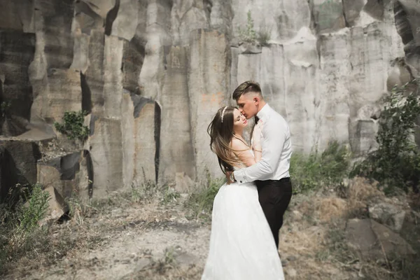 Vackra bröllopsparet i bergen med stenar — Stockfoto