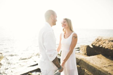 Deniz, mavi gökyüzü yakınındaki taş poz romantik sevgi dolu Çift