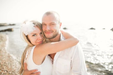 Mutlu evli genç bir çift kutluyor ve güzel sahil günbatımında eğleniyor..