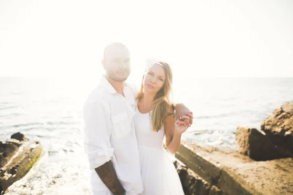 Просто одружена весільна пара, що йде на пляжі на заході сонця . — стокове фото