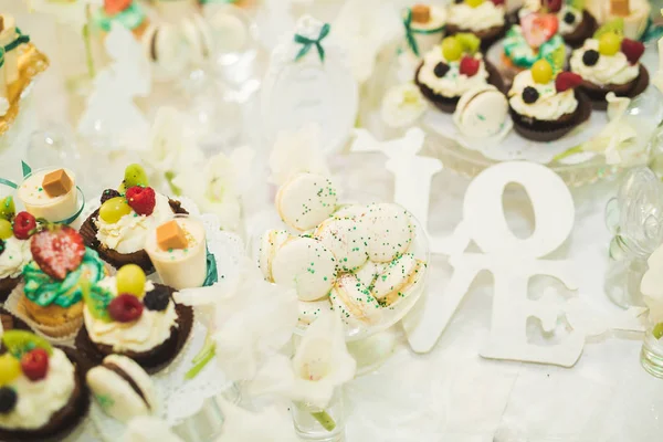 デザートと結婚式のキャンディービュッフェでおいしいお菓子、カップケーキ — ストック写真