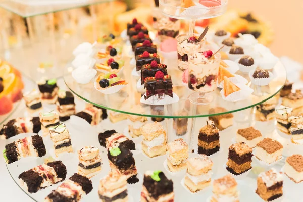 Läckra och välsmakande dessert bord med cupcakes skott i receptionen närbild — Stockfoto