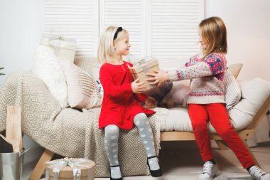 Sihirli hediye kutusu ve küçük bir kız bebek, Noel mucizesi, küçük mutlu, mutlu bir kız hediyelerle dolu bir kutuyu açıyor.