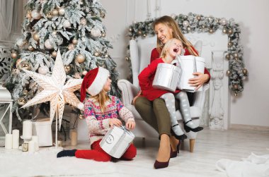 Anne ve kızları küçük kızların doğum günü hediyelerini açıyorlar.