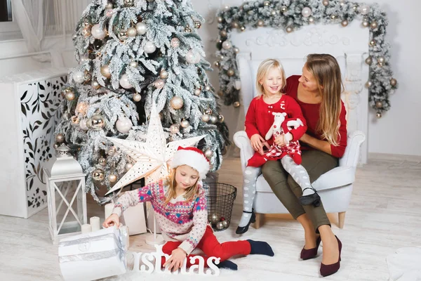 Anne ve kızları küçük kızların doğum günü hediyelerini açıyorlar.