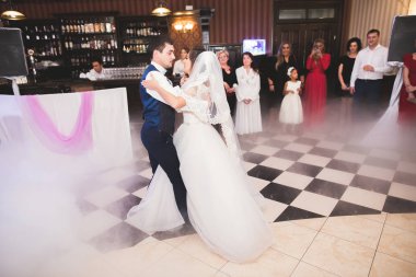 Güzel beyaz bir çift yeni evlendiler ve ilk danslarını ediyorlar.