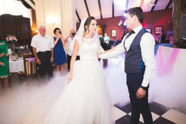 Güzel beyaz bir çift yeni evlendiler ve ilk danslarını ediyorlar.