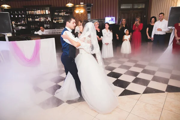 Güzel beyaz bir çift yeni evlendiler ve ilk danslarını ediyorlar.