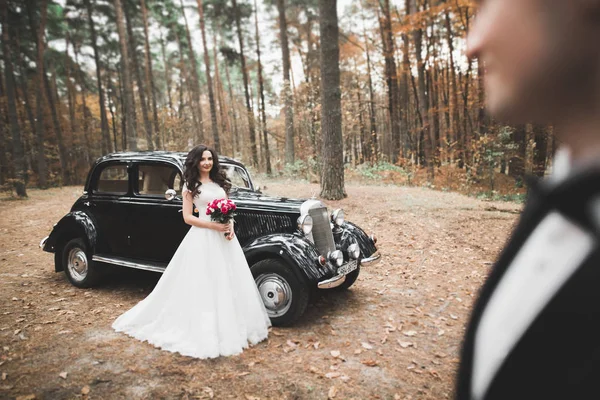Просто одружився щаслива пара в ретро-автомобілі на своєму весіллі — стокове фото