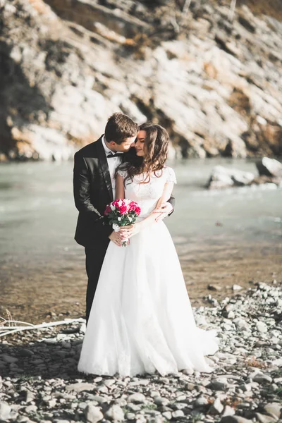 Élégant élégant mariée brune heureuse et marié magnifique sur le fond d'une belle rivière dans les montagnes — Photo