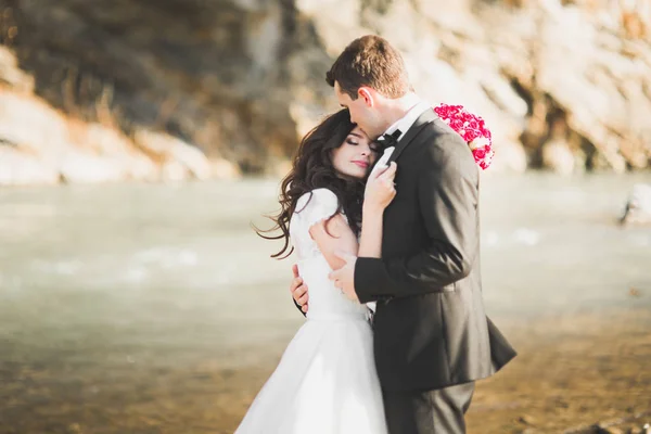 Casal de casamento, noivo e noiva abraçando, ao ar livre perto do rio — Fotografia de Stock