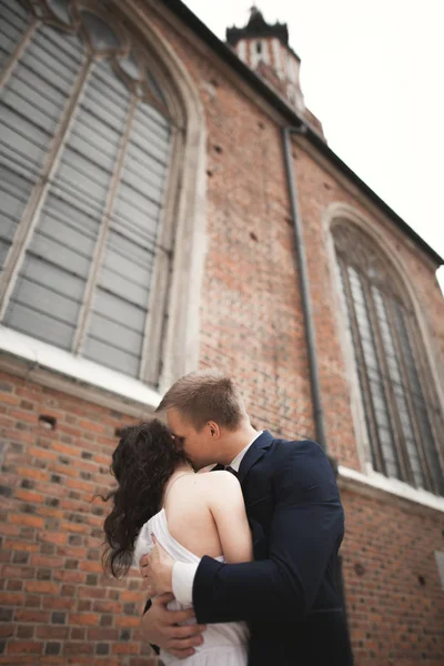 Nádherný Svatební pár, nevěsta, ženich pózuje u staré brány budova — Stock fotografie