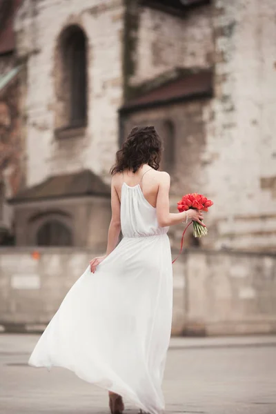 Vackra unga brud med brudbukett till bakgrunden kyrkan — Stockfoto