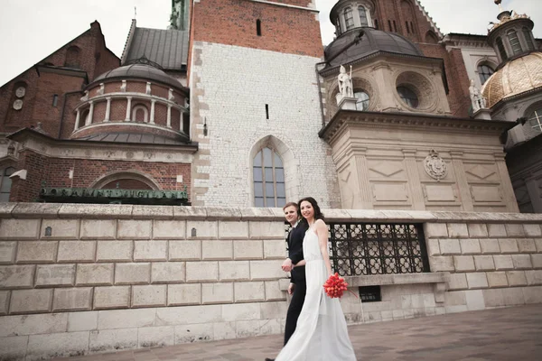結婚式のカップル、クラクフの教会近くに歩いて新郎新婦 — ストック写真