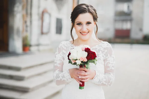 Noiva segurando grande e bonito buquê de casamento com flores — Fotografia de Stock