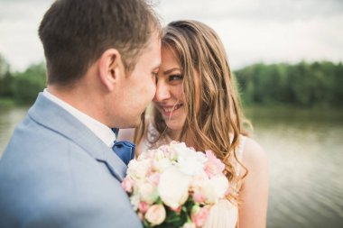 Gelin ve damat güzel düğün buket tutarak. Göl, orman