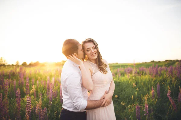 Beau couple de mariage, amour au coucher du soleil. Fielf aux fleurs — Photo