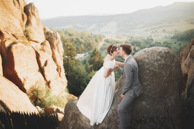 Muhteşem gelin ve şık damat yürüyüş güneşli manzara, Düğün çifti, lüks töreni dağların muhteşem manzaralı, metin için yer