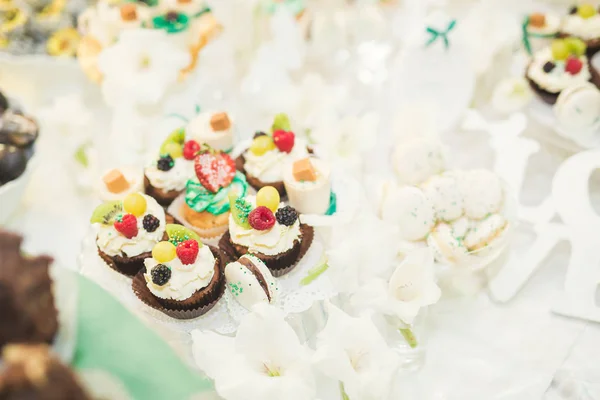 Délicieuse et savoureuse table à dessert avec des petits gâteaux plans à la réception gros plan — Photo