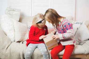 Sihirli hediye kutusu ve küçük bir kız bebek, Noel mucizesi, küçük mutlu, mutlu bir kız hediyelerle dolu bir kutuyu açıyor.