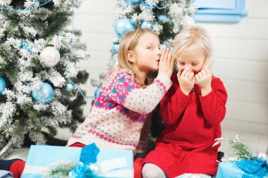 Mutlu küçük çocuklar Noel arifesinde hediyeleri açıyor.